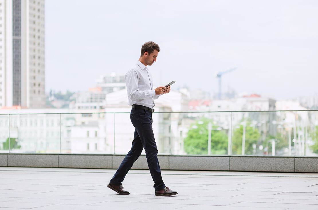 One man Elegant self-confident businessman a white shirt to go using a digital tablet in downtown