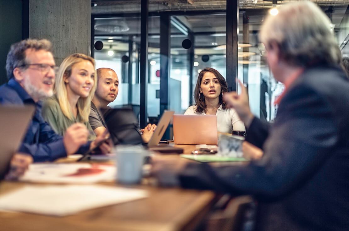 Multi-ethnic group of business people discussing ideas at a conference table in a modern office